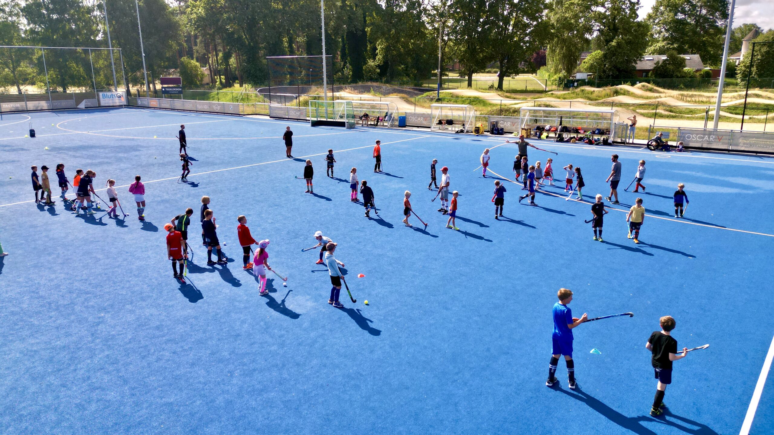 Jonge spelers trainen samen op het blauwe veld