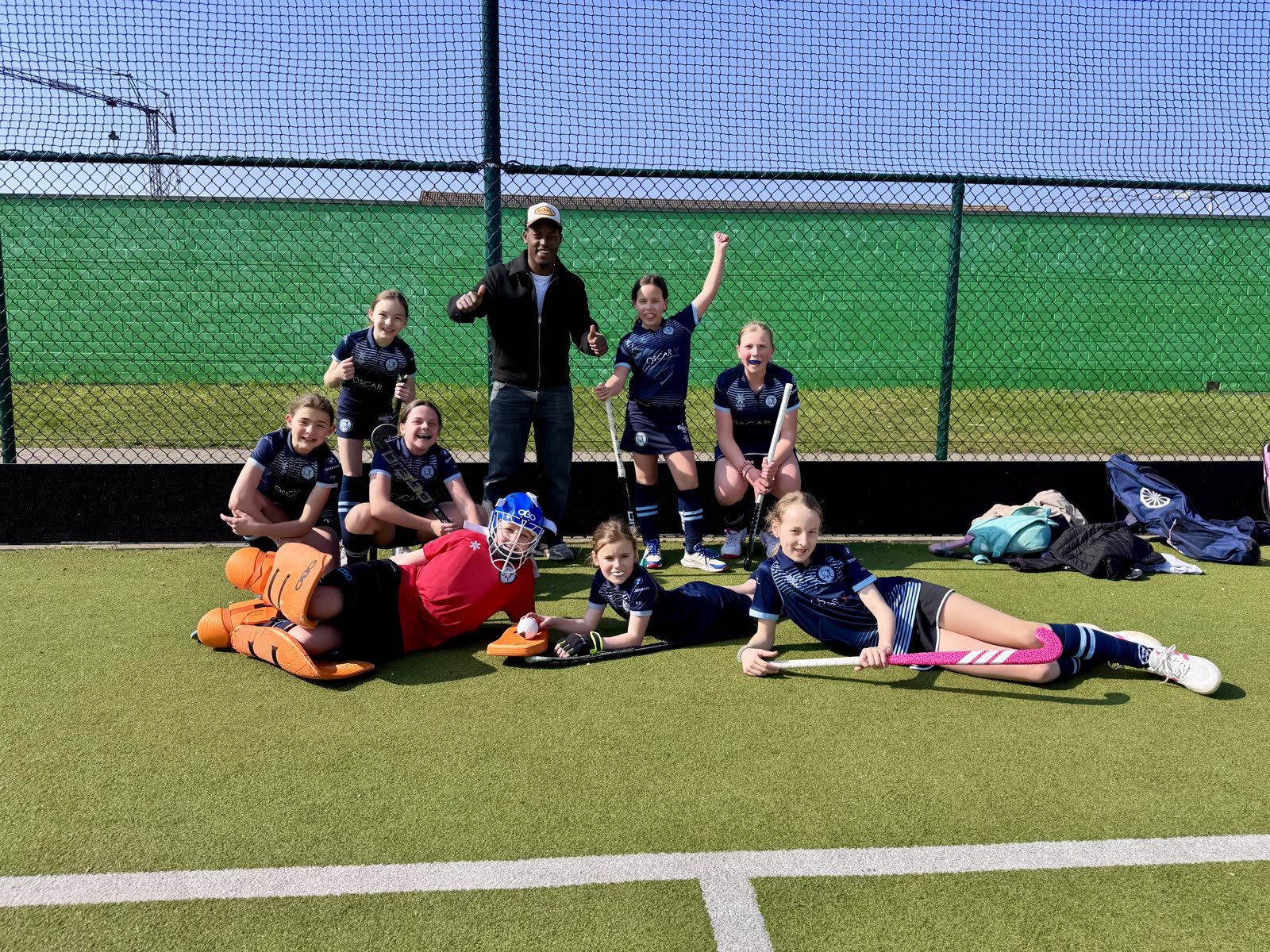 Jonge Tigers liggen lachend op het veld naast hun keeper