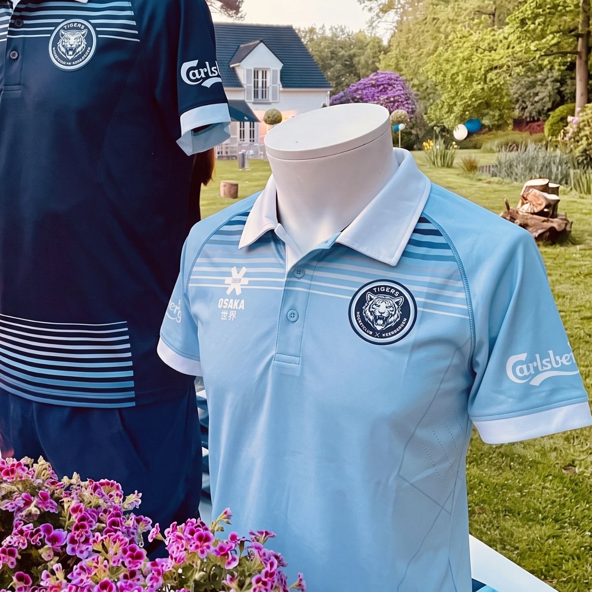Nieuwe clubkledij van de Tigers: lichtblauwe en marineblauwe polo met tijgerlogo en Carlsberg op de mouw